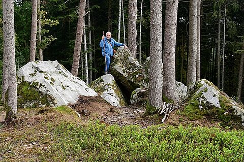Dr. Ulbig zeigt interessante Felsformationen im Wald. (Foto: Isolde Ulbig)