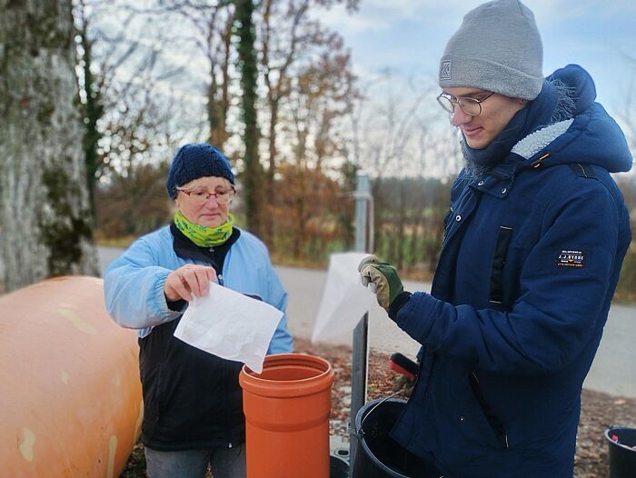 Naturium-Guides füllen die gesammelten Zigarettenkippen in das Sammel-Rohr. (Foto: Naturium am Inn)